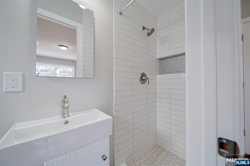 314 Garibaldi Avenue, Unit 1 Lodi, NJ 07644 - Photo 26 of 35 a bathroom with a sink a mirror and shower