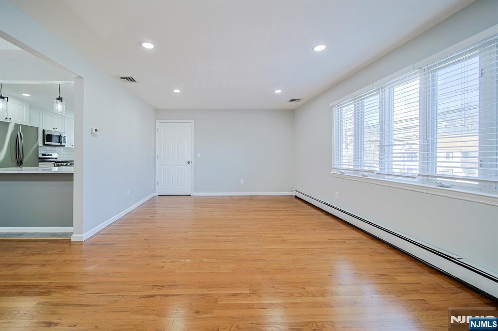 314 Garibaldi Avenue, Unit 1 Lodi, NJ 07644 - Photo 9 of 35 a view of an empty room with wooden floor and a window
