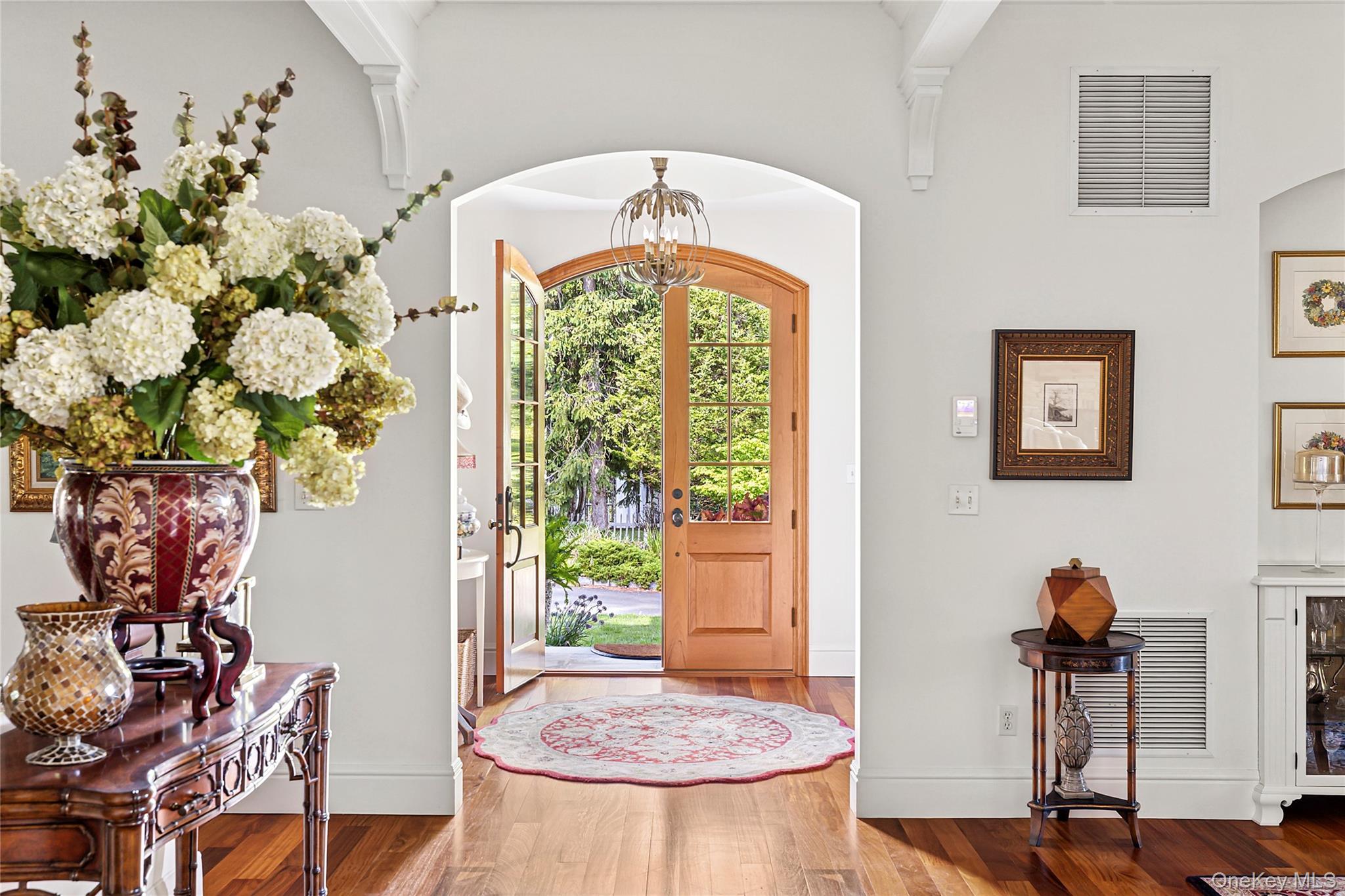 19 Ridge Lane Miller Place, NY 11764 - Photo 2 of 28 Foyer featuring wood finished floors, a chandelier, and arched walkways