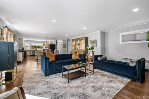 a living room with furniture kitchen view and a refrigerator