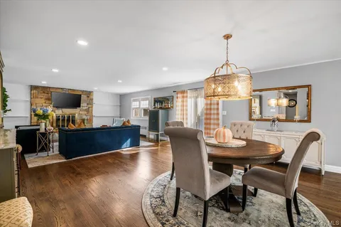 a view of a dining room with furniture a chandelier and wooden floor