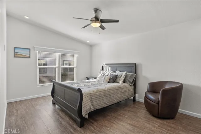 a bedroom with a bed a chandelier and a flat screen tv