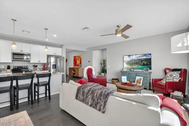 a living room with furniture kitchen view and a window