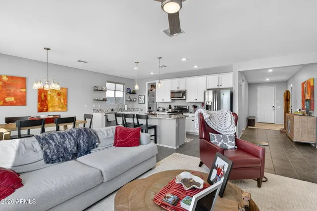 a living room with furniture kitchen view and a chandelier