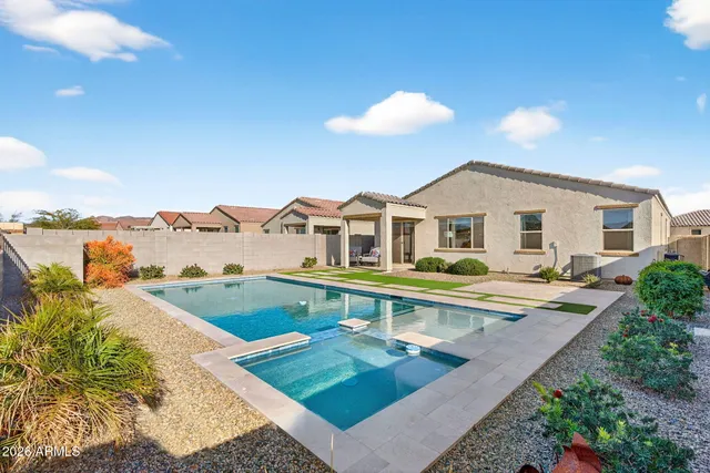 a view of a house with pool and chairs