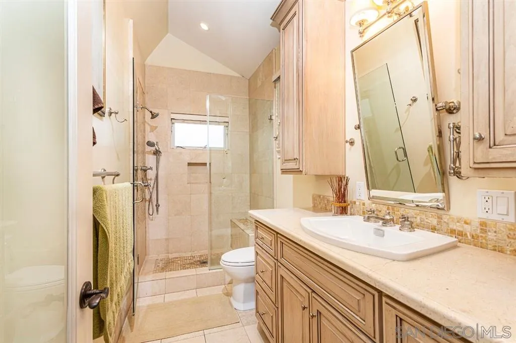 911 4th Street Coronado, CA 92118 - Photo 8 of 18 a bathroom with a granite countertop sink a toilet and shower