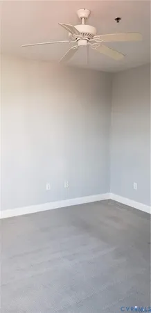a view of an empty room and chandelier fan