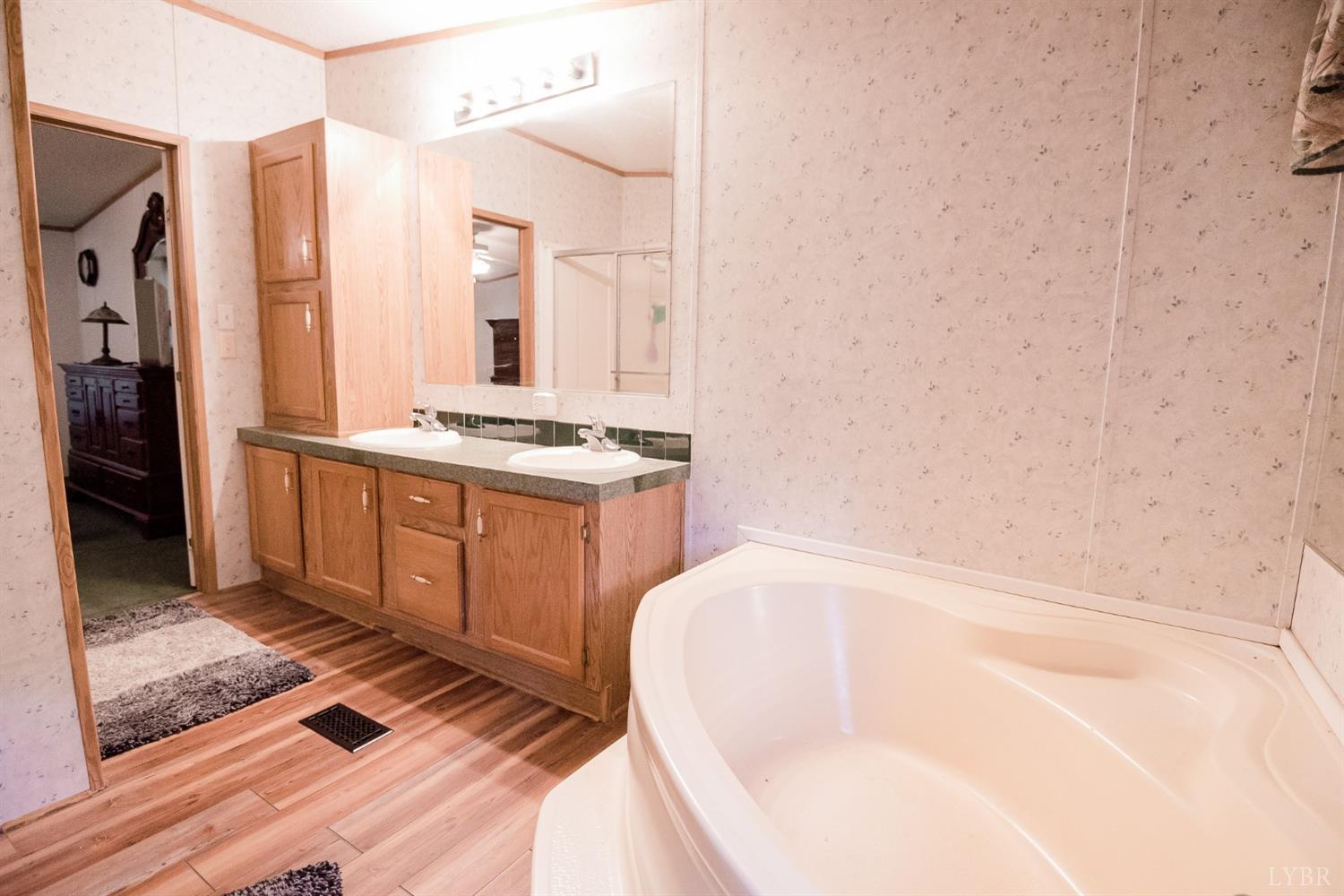 862 Snapps Mill Road Spout Spring, VA 24593 - Photo 20 of 29 a bathroom with a tub sink and mirror