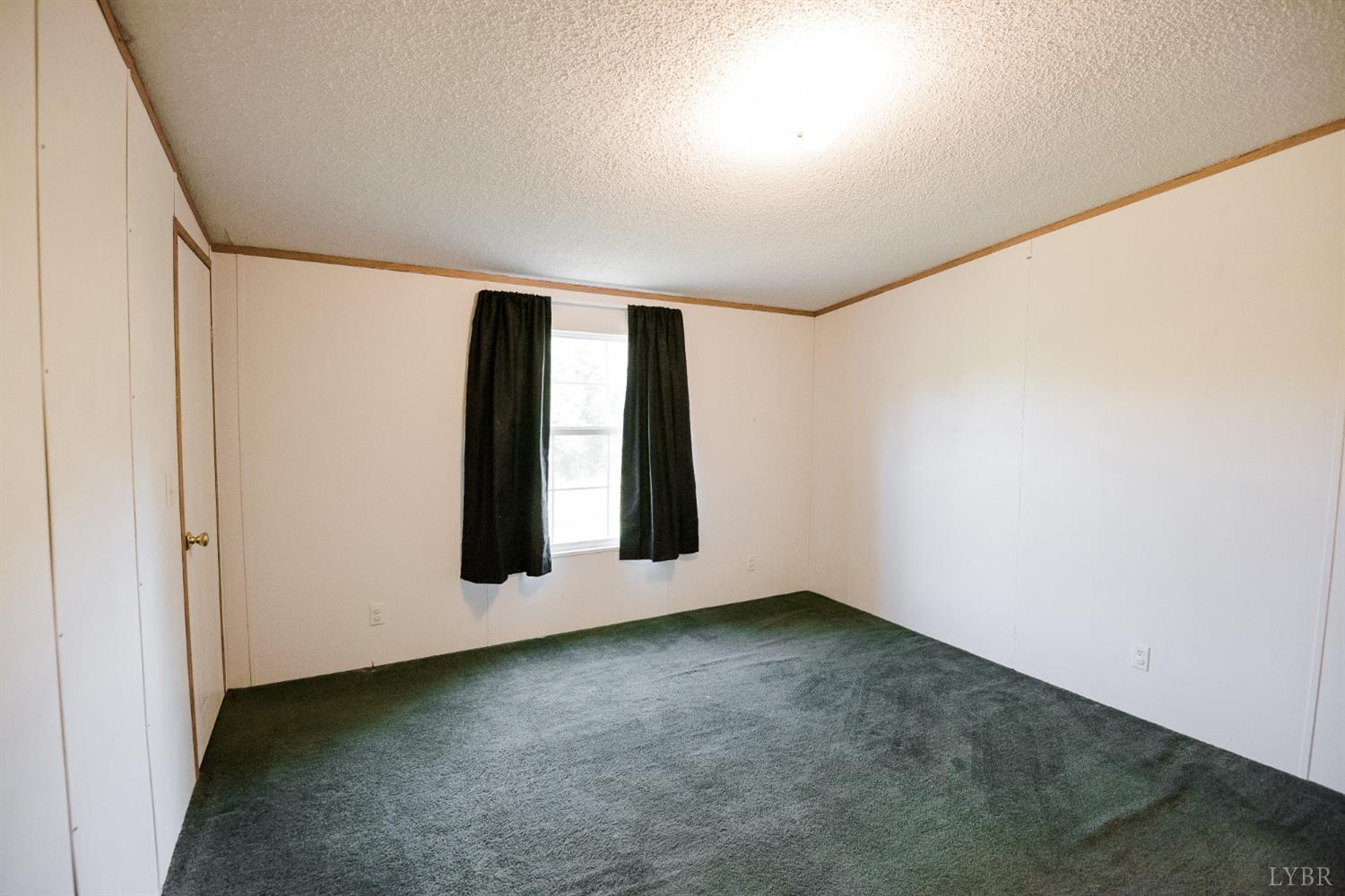 862 Snapps Mill Road Spout Spring, VA 24593 - Photo 23 of 29 an empty room with wooden floor and windows