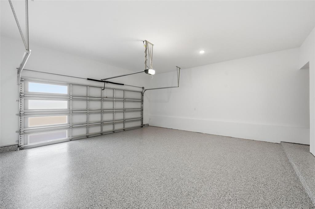 1168 Daybreak Drive, Unit 1168 Allen, TX 75013 - Photo 22 of 25 Garage space featuring an epoxy-coated floor, automatic garage door opener, and recessed lighting