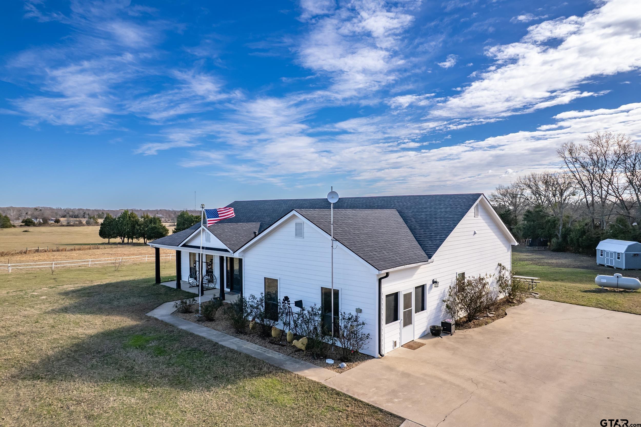 488 VZ County Road Ben Wheeler, TX 75754 - Photo 12 of 47 a view of a white house next to a yard with wooden fence