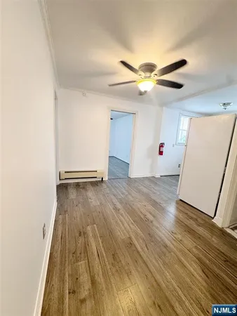 a view of empty room with wooden floor