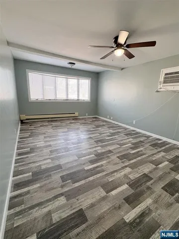 a view of empty room with window and ceiling fan