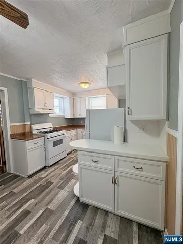 a kitchen with granite countertop white cabinets and white appliances