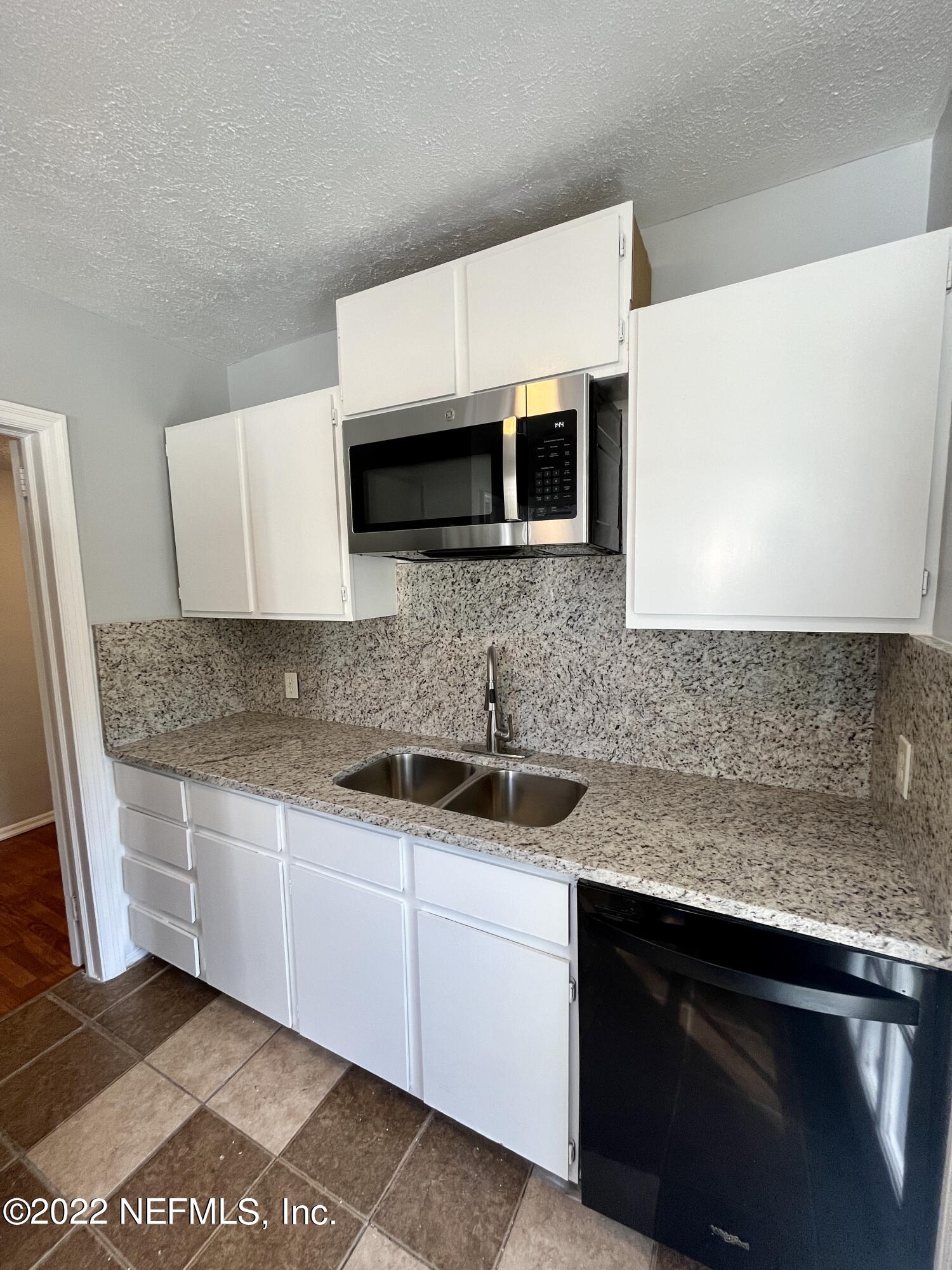 1752 Lilly Road East Jacksonville, FL 32207 - Photo 14 of 31 a kitchen with stainless steel appliances granite countertop a sink and a stove