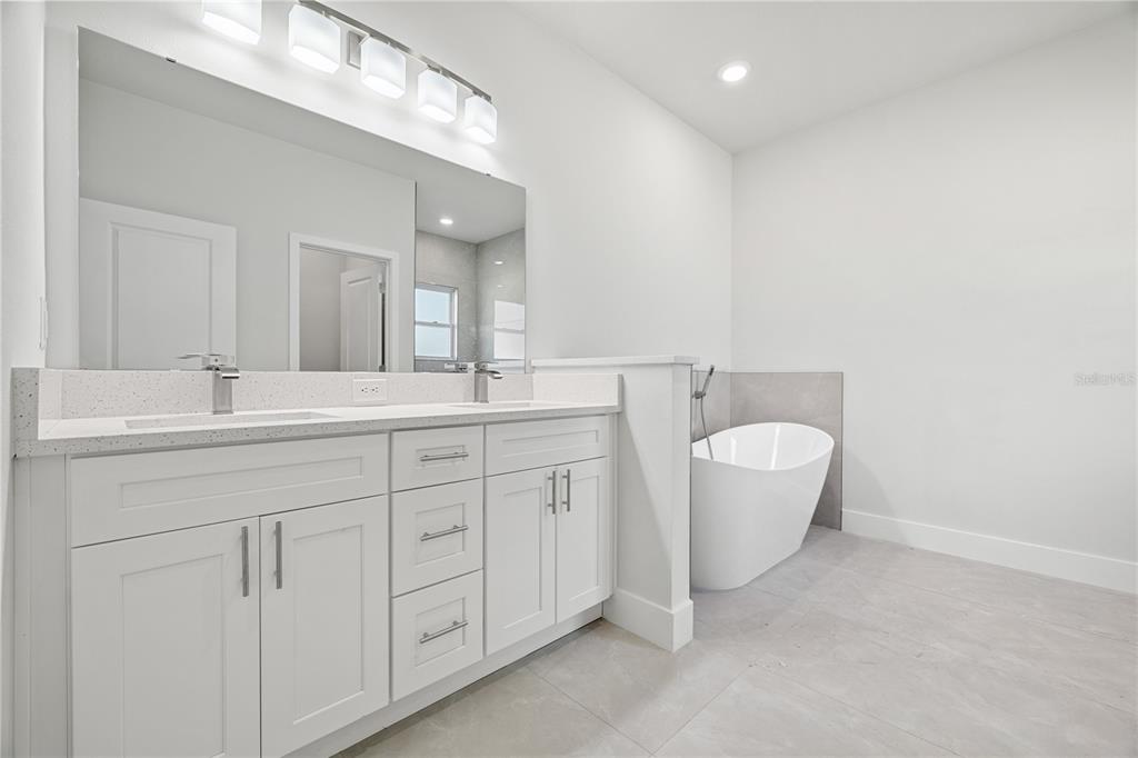 16281 Southwest 48th Circle Ocala, FL 34473 - Photo 24 of 26 a bathroom with a granite countertop sink mirror and bathtub