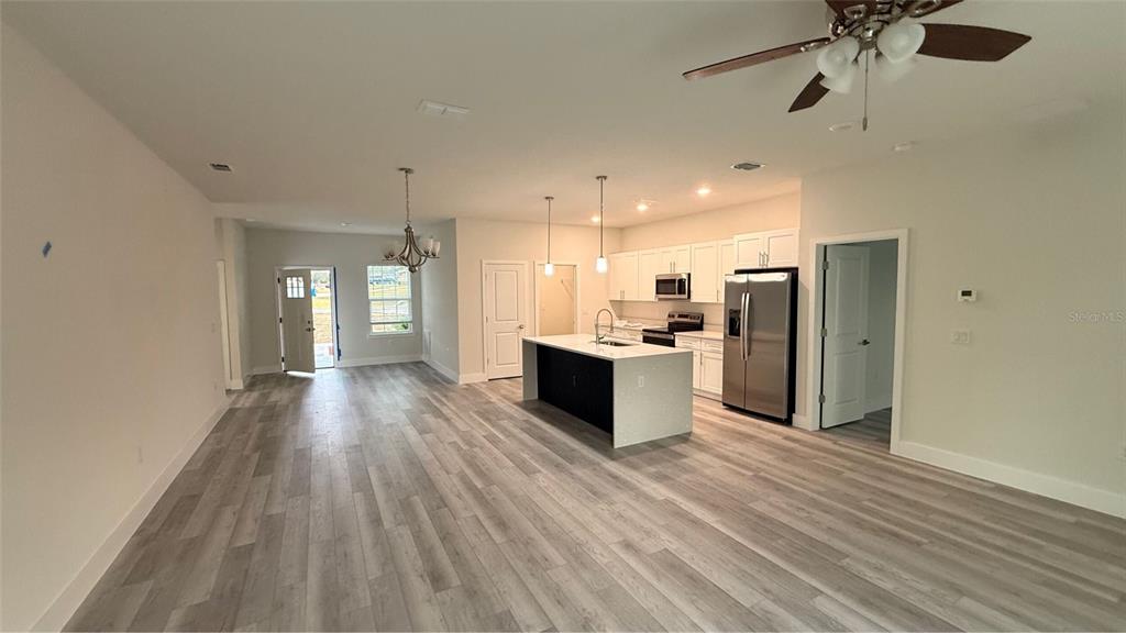 16281 Southwest 48th Circle Ocala, FL 34473 - Photo 4 of 26 a view of a kitchen with wooden floor and a refrigerator