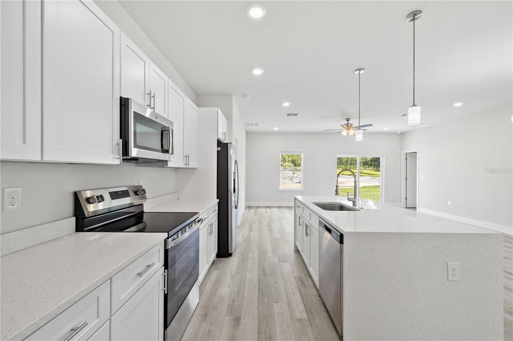 16281 Southwest 48th Circle Ocala, FL 34473 - Photo 6 of 26 a kitchen with stainless steel appliances granite countertop a sink a stove and a wooden floors
