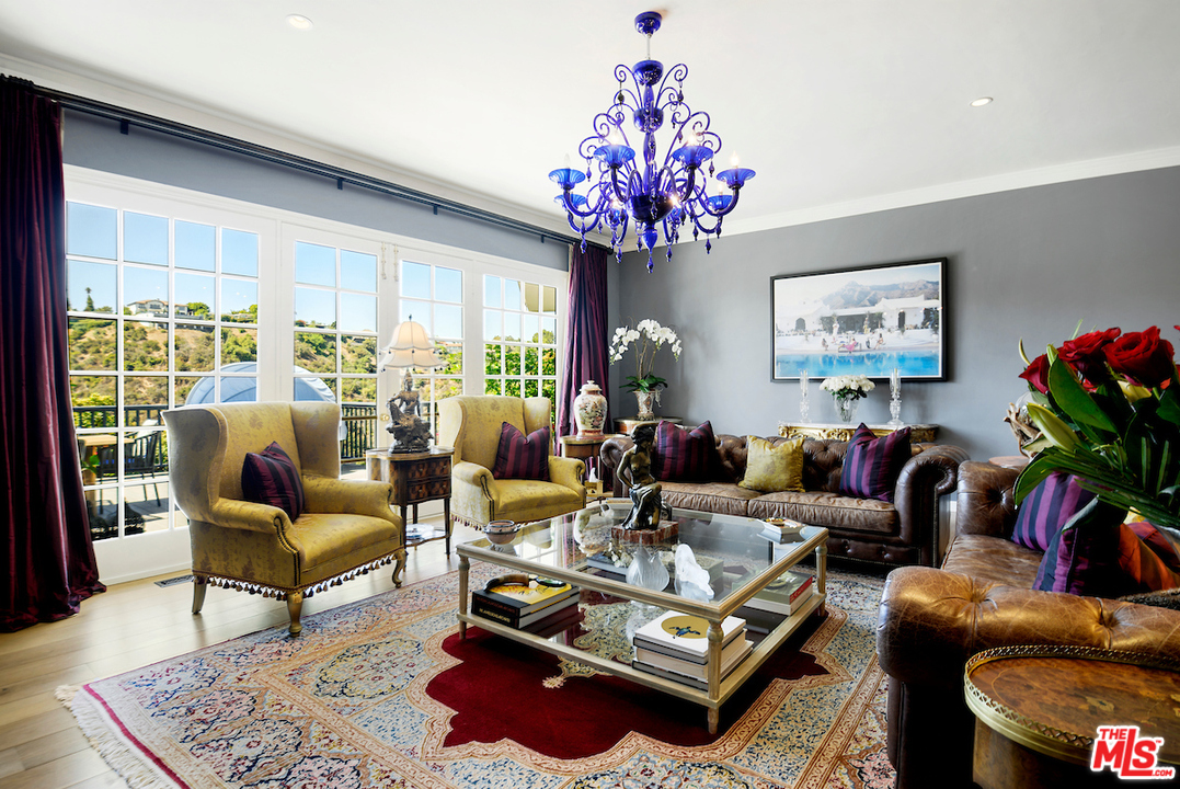 1077 Stradella Road Los Angeles, CA 90077 - Photo 3 of 25 a living room with furniture a chandelier and a large window