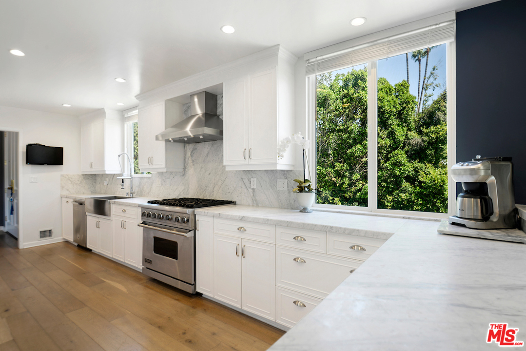 1077 Stradella Road Los Angeles, CA 90077 - Photo 9 of 25 a kitchen with stainless steel appliances white cabinets and a stove top oven