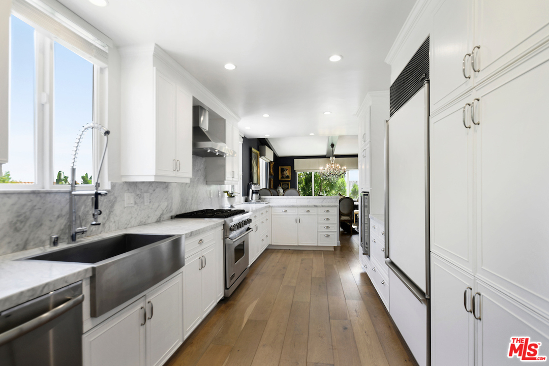 1077 Stradella Road Los Angeles, CA 90077 - Photo 10 of 25 a kitchen with a sink a counter top space stainless steel appliances and cabinets