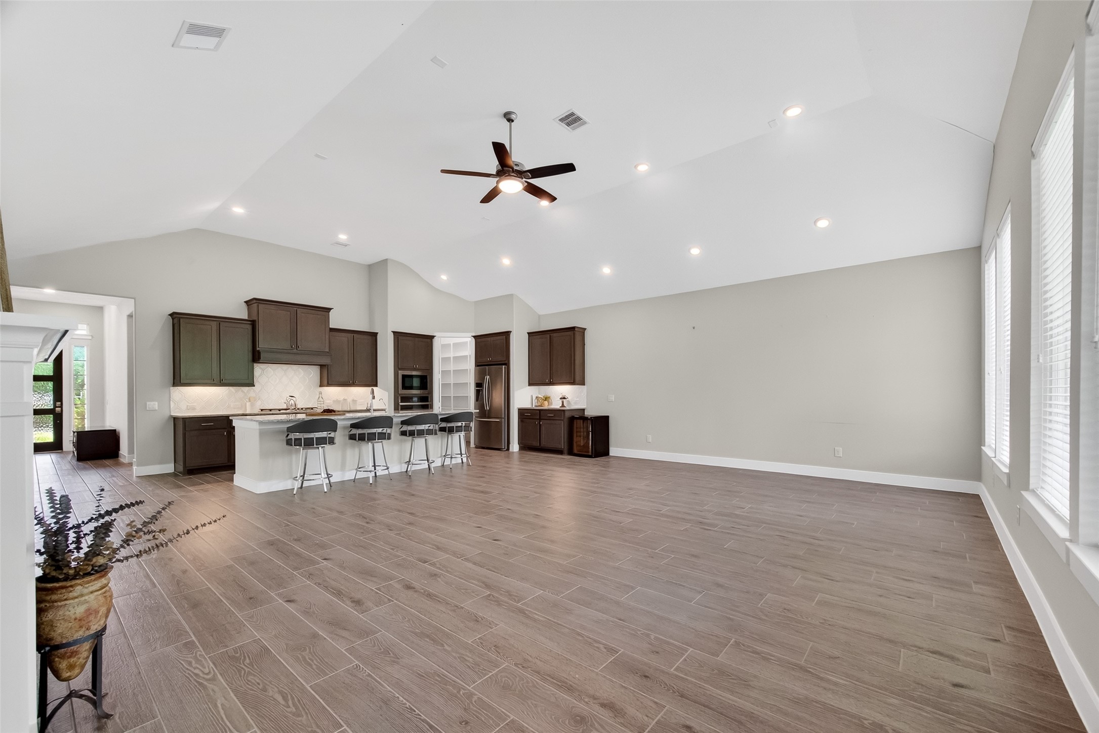 3415 Mckinney Ridge Drive Houston, TX 77059 - Photo 11 of 43 This spacious open-concept living area features recessed lighting, and ample natural light. The modern kitchen includes dark wood cabinetry, a central island with bar seating, offering a perfect blend of style and functionality.