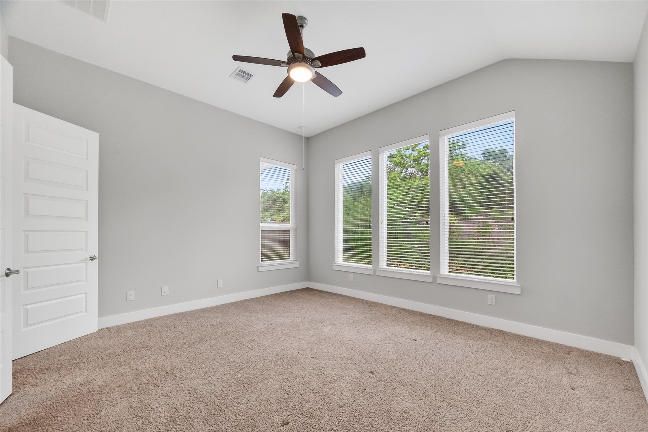 3415 Mckinney Ridge Drive Houston, TX 77059 - Photo 24 of 43 Primary bedroom with neutral walls & large windows offering natural light, carpeted flooring, and a ceiling fan. Relaxing view of the backyard gardens.