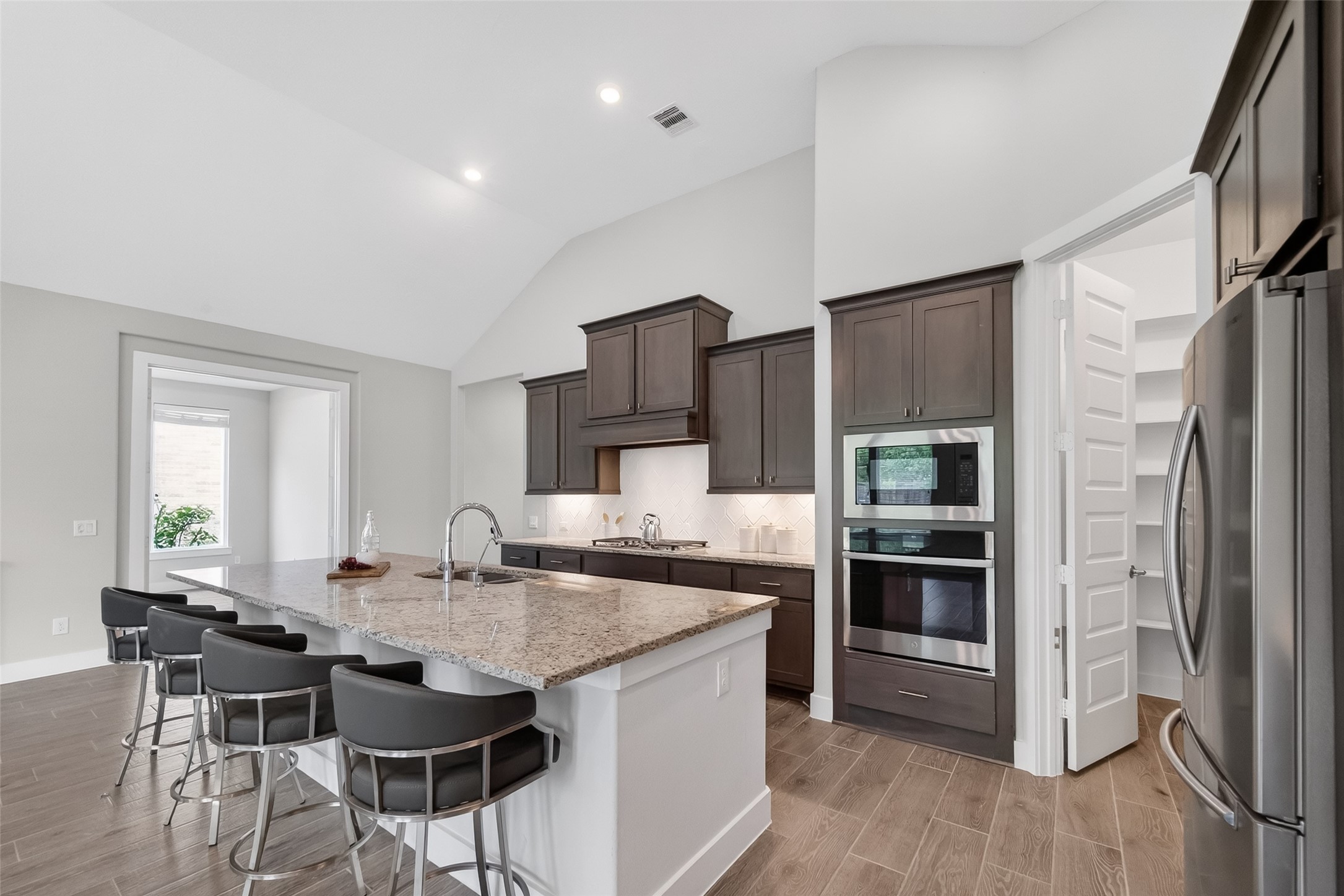 3415 Mckinney Ridge Drive Houston, TX 77059 - Photo 5 of 43 a kitchen with stainless steel appliances kitchen island granite countertop a refrigerator and a stove top oven