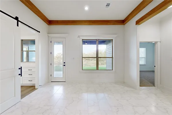 an empty room with a window and a fan