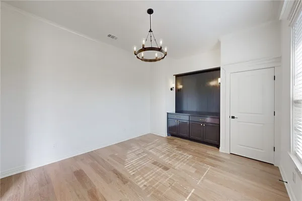 a view of an empty room with kitchen and fireplace