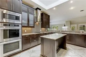 a kitchen with stainless steel appliances granite countertop a stove microwave and sink
