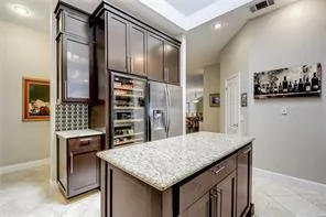 a kitchen with stainless steel appliances granite countertop a table chairs and refrigerator