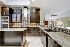 a kitchen with granite countertop a sink and a refrigerator