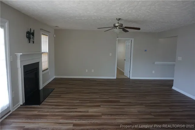 a view of a livingroom with wooden floor and a ceiling fan