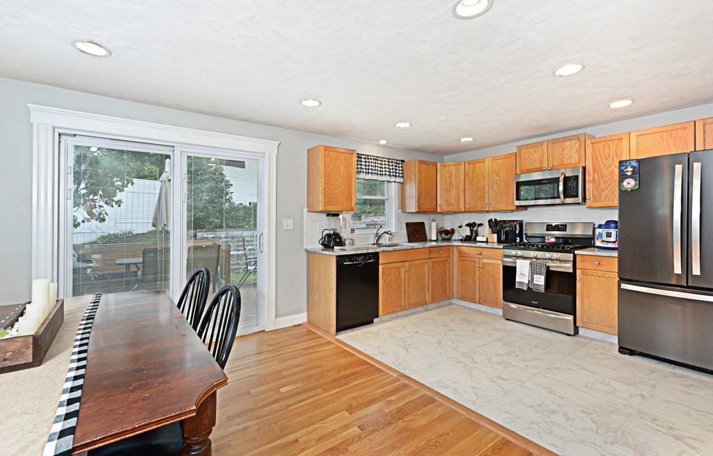 1 Hapgood Road Worcester, MA 01605 - Photo 8 of 34 a kitchen with granite countertop a refrigerator a stove a sink a dining table and chairs