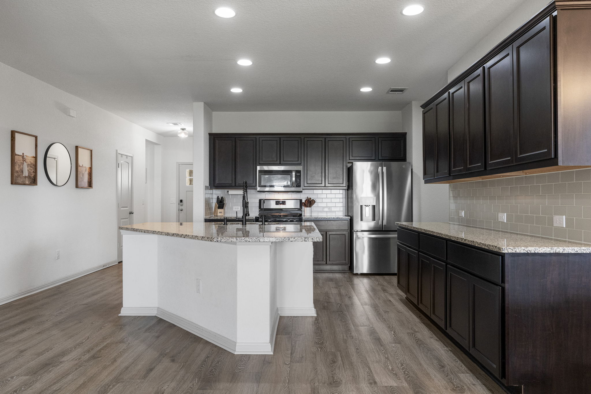 185 Struss Drive Georgetown, TX 78626 - Photo 4 of 23 A well-appointed kitchen showcasing an inviting island with granite counters, dark wood cabinetry, and sleek stainless steel appliances.