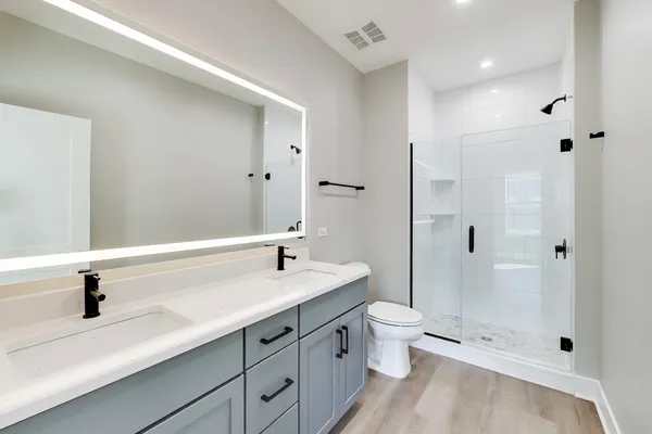 a bathroom with a sink a toilet and shower