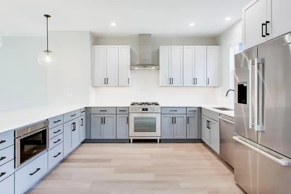 a large kitchen with cabinets stainless steel appliances and a counter space