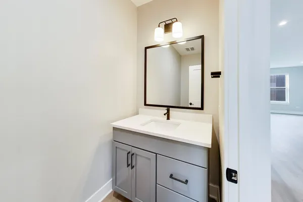 a bathroom with a sink vanity and mirror