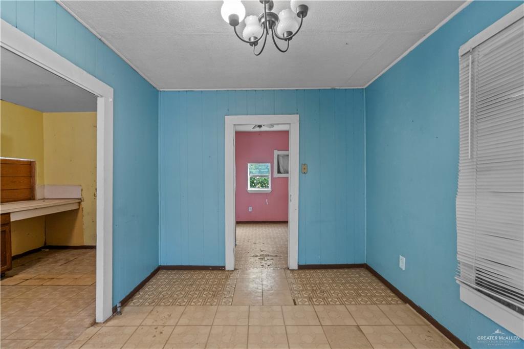 706 Doherty Avenue Mission, TX 78572 - Photo 7 of 21 a view of a hallway to a room with a dining room and chandelier
