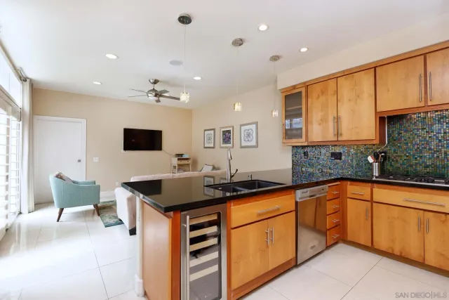 a kitchen with stainless steel appliances granite countertop a refrigerator a stove and a sink with wooden floor