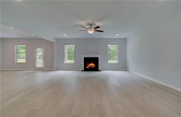 an empty room with windows and fireplace