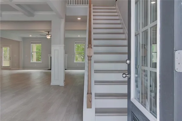 a view of a hallway with wooden floor and windows
