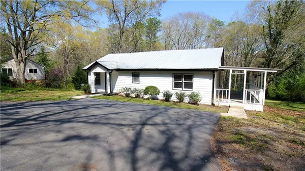 a view of a house with backyard and trees