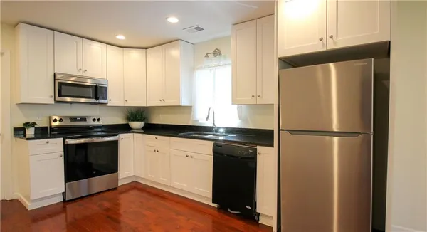 a kitchen with granite countertop a refrigerator stove and microwave