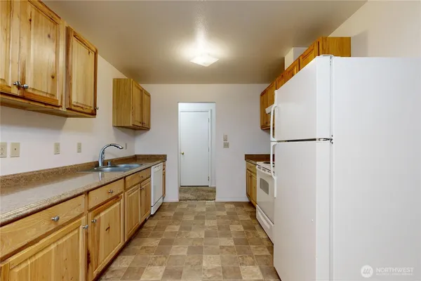 a kitchen with granite countertop a refrigerator and a sink