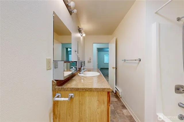 a bathroom with a granite countertop sink and a mirror