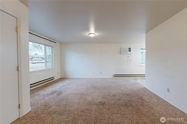 an empty room with windows and closet