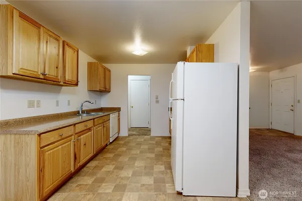 a large kitchen with stainless steel appliances granite countertop a refrigerator and a sink