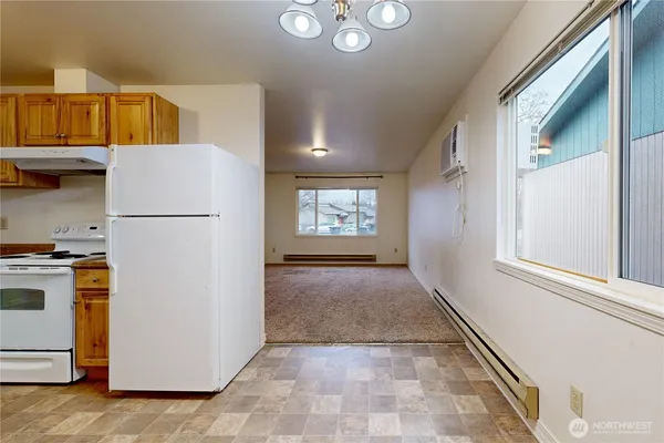 a view of a kitchen with fridge and wooden floor